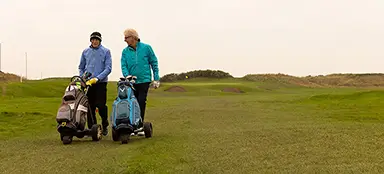 Mike walking on golf course with friend