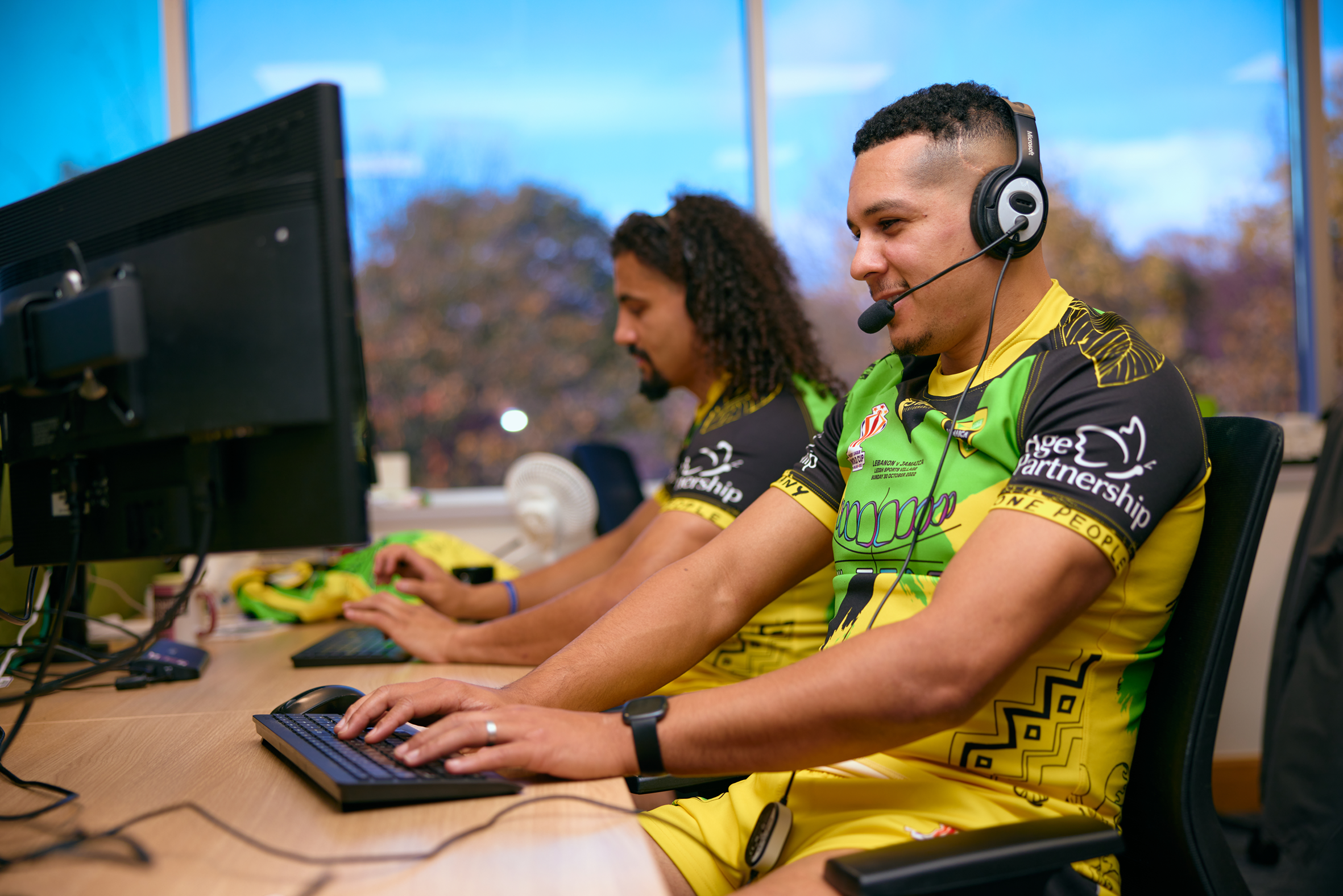 Jamaican rugby team members working on computers